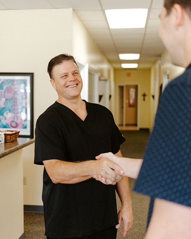 Dr. Charles Corfman shaking hands with a patient.